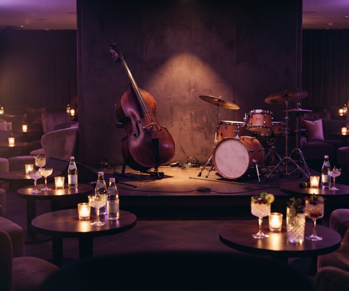 An intimate jazz lounge with a double bass and drum kit under warm purple light